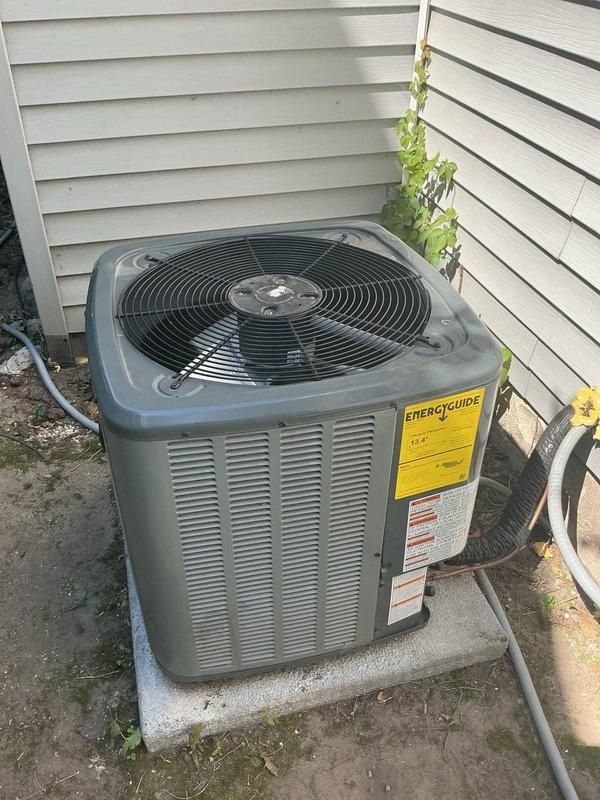 Responded to no-cool service call for residential AC unit experiencing operational issues due to physical damage. Upon arrival, found condenser fan blade bent and producing excessive noise after ice falling from roof struck the unit. The AC system had been installed the previous year in a location susceptible to ice accumulation and falling debris from the roofline above. Documented existing installation concerns, photographed damaged fan assembly and overall unit condition showing weathering and environmental exposure. Unit displaying signs of compromised airflow due to damaged fan components. Recommended fan blade replacement and evaluation of unit placement to prevent future damage from falling ice or debris.