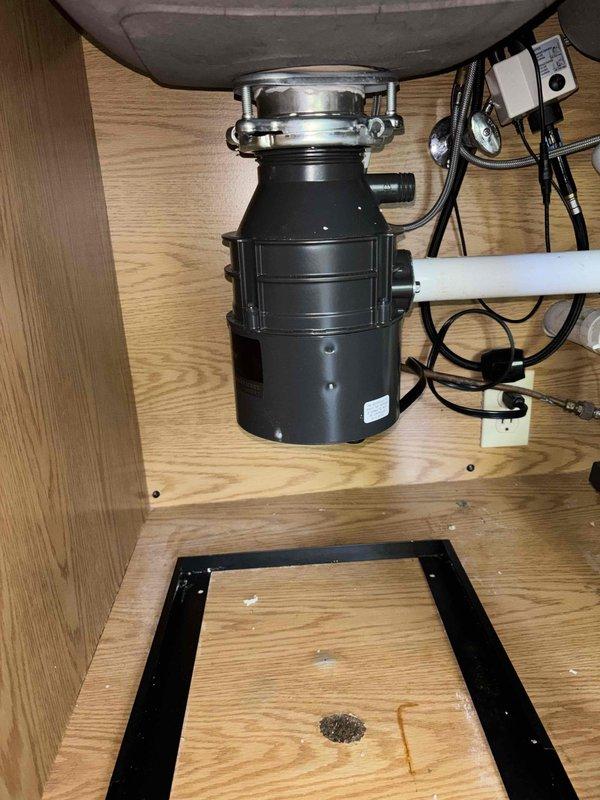 Responded to service call for leaking garbage disposal. Upon arrival, confirmed disposal was leaking when water was run into that side of the sink. Inspected unit and mounting assembly under sink. Documented existing conditions with photos showing disposal installation and sink basin. Completed diagnostic evaluation of disposal unit and plumbing connections to identify source of leak.