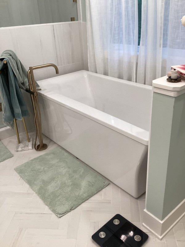 Responded to plumbing leak complaint regarding bathtub leaking consistently during use, exceeding normal drip rate. Performed visual inspection of freestanding tub installation with brass tub filler fixture and surrounding plumbing connections. Utilized digital inspection camera with flexible probe to examine internal drain assembly and overflow components for source of water intrusion. Documented bathroom conditions including herringbone tile flooring and modern tub installation. Enrolled customer in facility and home maintenance club membership for ongoing service coverage.