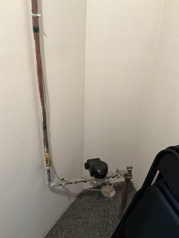 Conducted on-site assessment for backflow preventer installation at residential property. Evaluated existing plumbing infrastructure, including aging copper supply lines with visible patina and current meter/valve assembly configuration at floor level in utility area. Documented current system layout and connection points to determine optimal placement and specifications for required backflow prevention device installation.