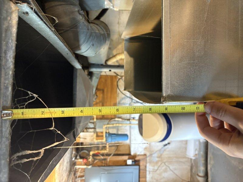 Responded to no cooling complaint with outdoor unit running. Upon inspection, discovered severely condensed and frosted supply ductwork in attic space, indicating inadequate insulation and significant temperature differential causing moisture accumulation. Identified improper duct insulation as primary cause of reduced cooling efficiency and warm air delivery to living space. Documented condensation coverage on metal ductwork and measured clearances for proper airflow assessment. Recommended duct insulation upgrade to prevent continued condensation issues and restore proper system performance.