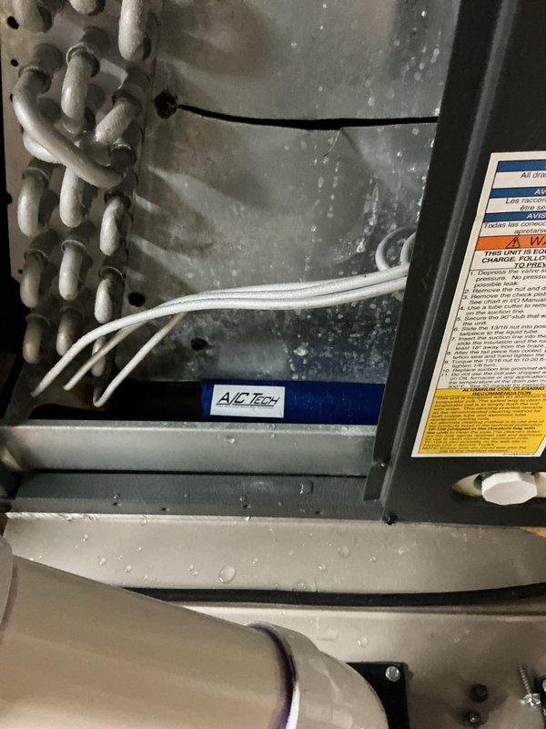 Completed annual cooling maintenance on EnergiAir system under 4-year warranty coverage. Performed comprehensive tune-up including evaporator coil inspection through access panel, verified heat exchange components operating within specifications, and documented drain pan condition. System components photographed showing proper installation of condensate management equipment, HVAC sensors, and refrigerant lines in good working order with normal dust accumulation on interior surfaces.