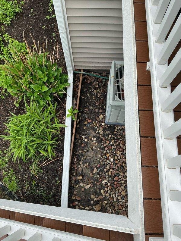Performed proactive sales estimate for replacement of 25-year-old residential air conditioning system in condo unit. Existing unit currently operational with no reported performance issues. Inspected HVAC equipment and ductwork in basement mechanical area, noting condensation present on galvanized metal ductwork surfaces and moisture staining on concrete floor beneath system. Evaluated exterior condenser unit located in narrow side yard area between buildings on gravel and mulch surface. Documented existing system configuration and conditions through photographic assessment to provide accurate replacement recommendations for aging equipment nearing end of expected service life.