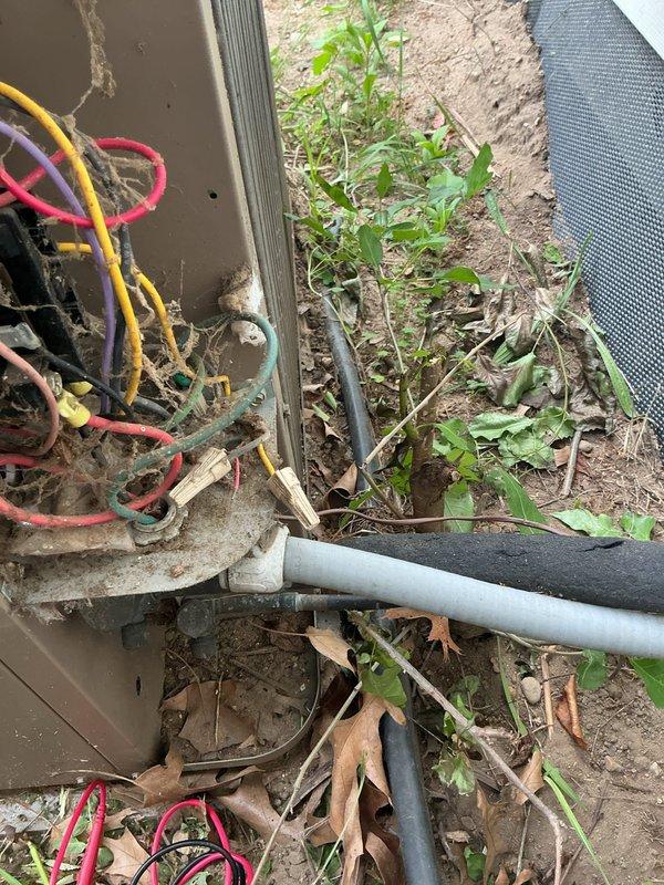 Responded to service call for 12-year-old air conditioning unit with non-operational fan affecting entire system. Upon inspection, discovered severely corroded and mineral-clogged copper piping with significant internal buildup restricting flow. Documented existing wiring configuration and outdoor unit installation showing disorganized electrical connections and weathered components requiring attention. Photographed deteriorated pipe section displaying heavy scale deposits and reduced internal diameter due to hard water conditions and age-related corrosion.
