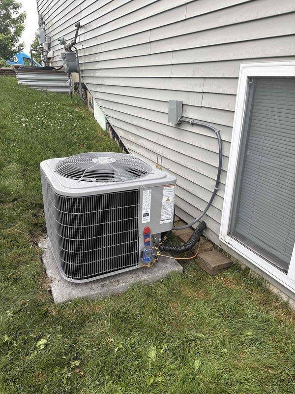Completed full residential air conditioning system replacement. Removed existing outdoor condenser unit and installed new AC condenser on concrete pad against exterior wall with proper refrigerant line connections, electrical conduit routing, and service gauge access points. System commissioned and tested for proper operation with all refrigerant lines properly insulated and secured to building structure.