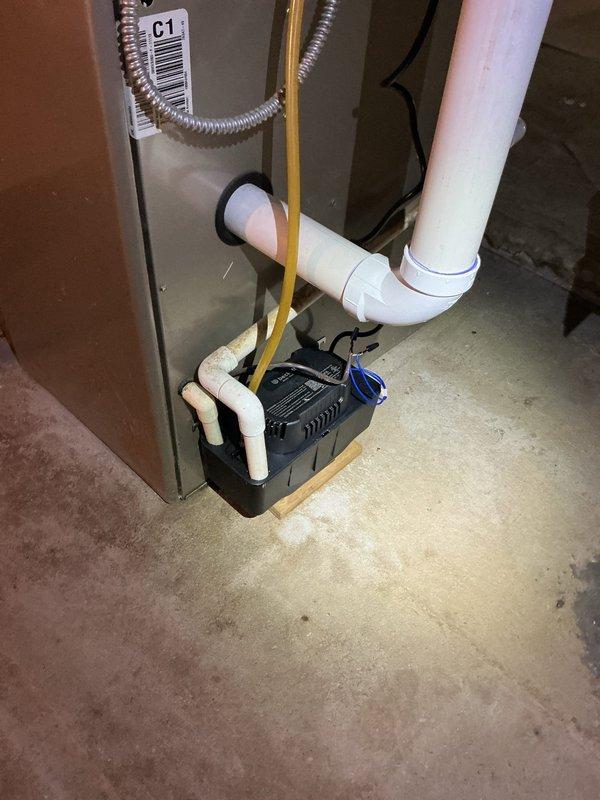 Responded to service call for odor and knocking sound occurring during AC operation on 18-year-old system. Inspected HVAC unit and condensate pump assembly in basement. Found blower motor assembly required attention due to accumulated debris and potential bearing issues causing mechanical noise. Cleaned blower motor housing and verified proper operation of condensate drainage system to eliminate odor source from standing water or biological growth in drain lines.