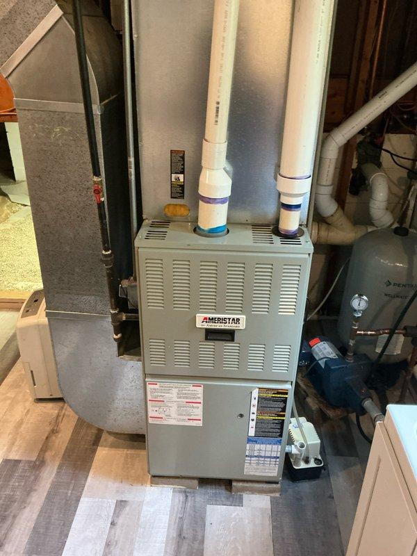 Provided estimate for complete air conditioning system installation at property with existing Ameristar natural gas furnace and condensate pump but no cooling capability. Quote includes wall-bracket mounted condensing unit, cased evaporator coil, refrigerant line set, and coil condensate drain line with proper routing to existing pump. Homeowner possesses HVAC/R experience and may assist with installation to reduce labor costs.