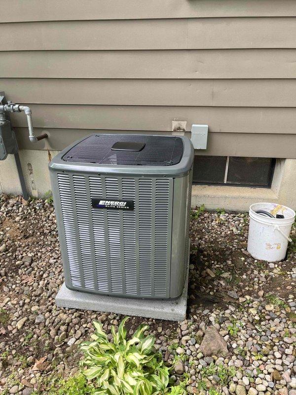 Completed full air conditioning system replacement including outdoor condenser unit and indoor air handler. Removed existing equipment and installed new condenser on concrete pad against exterior wall with proper clearances. Mounted electrical disconnect box on exterior wall per code requirements. Installed new air handler in basement mechanical room adjacent to existing furnace. Connected refrigerant lines between outdoor and indoor units with proper insulation. Ran condensate drain lines using PVC piping with appropriate pitch and termination. Completed all electrical connections and verified proper voltage and amperage. Pressure tested refrigerant system, evacuated to proper micron level, and charged system to manufacturer specifications. Verified all safety controls, thermostat communication, and system operation through multiple heating and cooling cycles. System operating within normal parameters with proper airflow and temperature differential across coil.