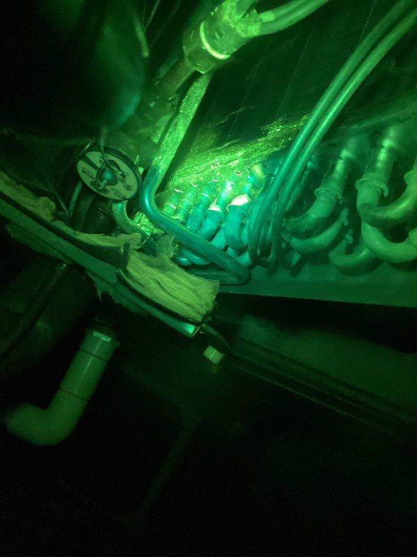 # CP-Cooling Problem Follow-Up

Returned to 12-year-old ICP heat pump system for loss of cooling following recent refrigerant charge and UV dye injection. Performed UV leak detection inspection using specialized lighting on evaporator coil and refrigerant lines. Photos documented UV dye traces under inspection lighting to identify leak location within the system. Evaporator coil assembly and associated refrigerant piping connections inspected for active leak points. Customer advised of findings and repair options for refrigerant leak to restore system cooling capacity.