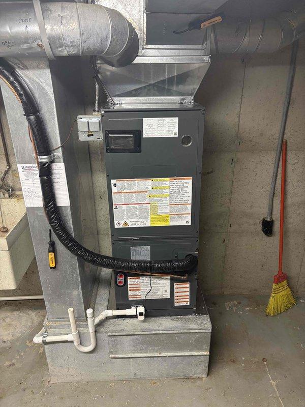 Completed full installation of residential HVAC system including air handler and condensing unit in basement utility space. Installed new furnace cabinet with proper clearance on concrete platform, connected metallic supply ductwork and black flexible return ducting, and established PVC condensate drainage piping. System was properly mounted, all ductwork connections secured, electrical and refrigerant lines run between indoor and outdoor units, and equipment tested for proper operation upon startup.