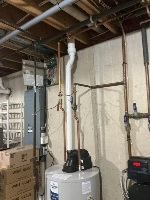 Completed installation of a 50-gallon Power Vent LP water heater in basement utility area. Configured all necessary plumbing connections including copper supply lines with shut-off valves, PVC venting system routed through ceiling joists, and integrated unit with existing mechanical systems. Installation verified operational with all connections tested and system functioning properly.
