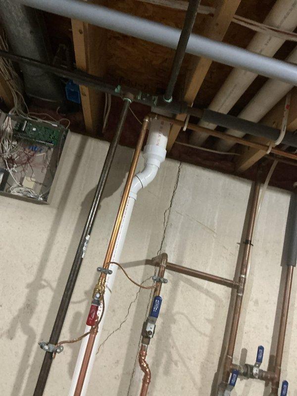 Completed installation of a 50-gallon Power Vent LP water heater in basement utility area. Configured all necessary plumbing connections including copper supply lines with shut-off valves, PVC venting system routed through ceiling joists, and integrated unit with existing mechanical systems. Installation verified operational with all connections tested and system functioning properly.