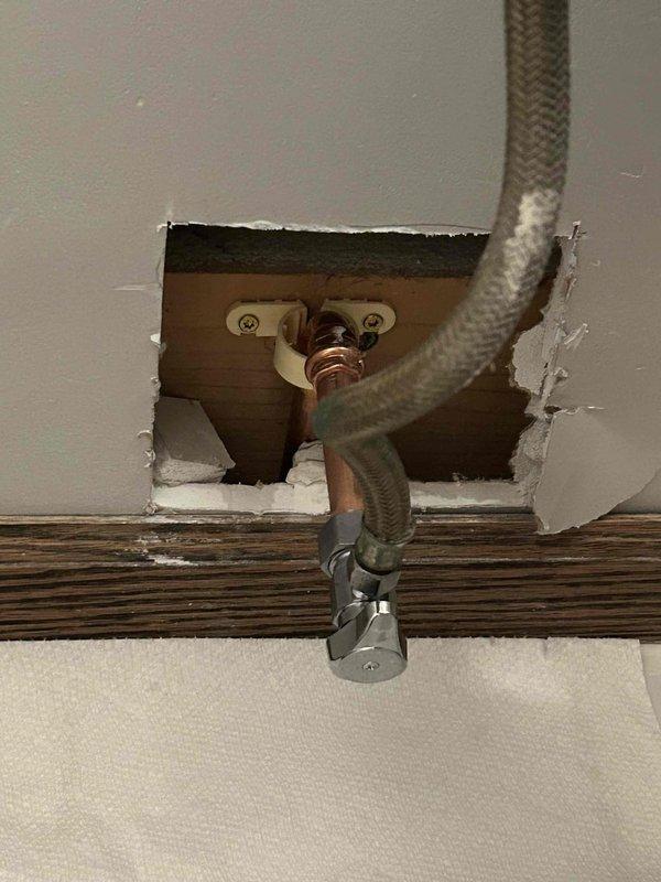 Completed copper pipe repair requiring wall access. Cut access opening in drywall to expose damaged copper supply line and flexible braided connectors at fixture mounting location. Replaced compromised section of copper piping and reconnected braided supply lines to shut-off valve. Secured new copper pipe run to wooden framing in crawl space using appropriate copper hangers and fasteners. Verified all connections for proper fit and tested system for leaks. Wall opening left accessible for customer inspection prior to drywall closure.