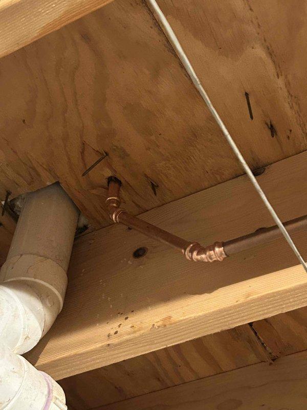 Completed copper pipe repair requiring wall access. Cut access opening in drywall to expose damaged copper supply line and flexible braided connectors at fixture mounting location. Replaced compromised section of copper piping and reconnected braided supply lines to shut-off valve. Secured new copper pipe run to wooden framing in crawl space using appropriate copper hangers and fasteners. Verified all connections for proper fit and tested system for leaks. Wall opening left accessible for customer inspection prior to drywall closure.