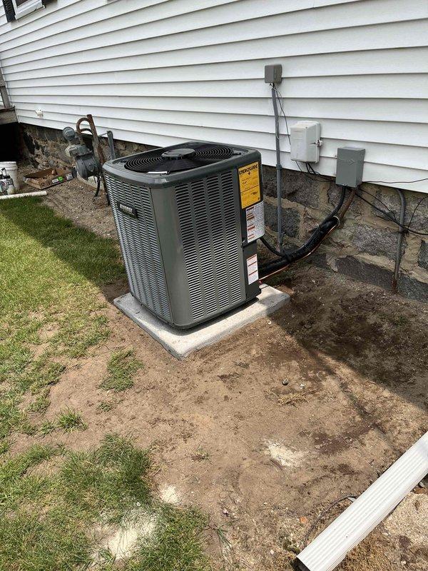 Complete residential HVAC system installation performed, including new furnace and air conditioning condenser unit. Furnace installed in basement utility area on raised platform with proper clearances, connected to new metallic supply ductwork and PVC condensate drainage system. Air handler positioned adjacent to furnace with digital control panel for system management. Outdoor AC condenser unit installed on concrete pad with proper leveling, positioned on house exterior with adequate clearance from structure. Refrigerant lines run from condenser through foundation to indoor equipment with appropriate insulation. Electrical disconnect box mounted on dedicated pole near outdoor unit for service accessibility. All connections made to existing electrical service panel and meter. System commissioned and verified for proper operation of both heating and cooling functions.