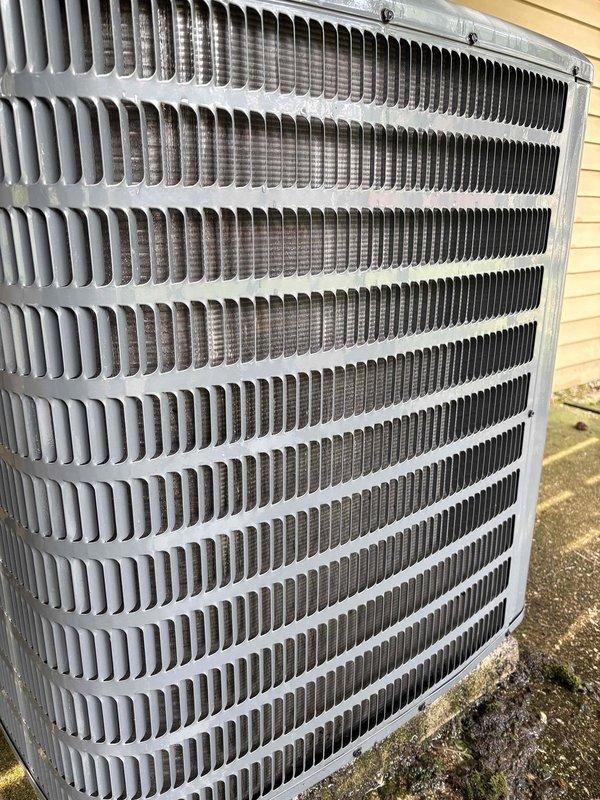 Responded to no cooling complaint on 6-year-old air conditioning system in manufactured home. Upon arrival, customer reported unit running but delivering insufficient cooling. Performed diagnostic evaluation of outdoor condenser unit using digital testing equipment to assess system performance and identify cause of reduced cooling capacity. Documented equipment condition through photographs showing condenser coil and exterior components for service records.