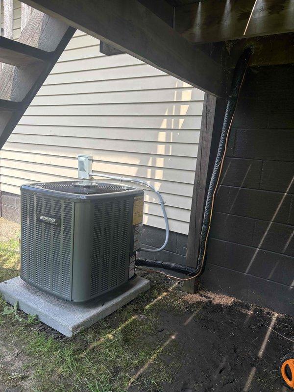 Completed full installation of residential furnace and air conditioning system. Outdoor condensing unit was professionally mounted on concrete pad beneath deck structure with proper electrical conduit and refrigerant line connections to interior air handler. System was charged with refrigerant, pressures were tested and verified using manifold gauges to ensure optimal performance within manufacturer specifications, and all components were commissioned for operation.
