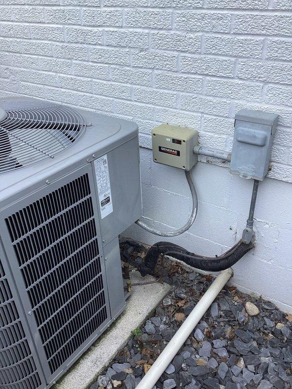 Responded to service call for one-year-old Carrier unit not cooling properly. Upon arrival, performed diagnostic inspection of outdoor condenser unit and associated electrical components. Inspected electrical disconnect box, control wiring, and power supply connections mounted on exterior wall. Verified proper voltage supply and examined conduit runs between disconnect and unit. Checked condenser fan operation, refrigerant line connections, and condensate drain system. Documented equipment installation including AC condenser positioning on concrete pad, electrical service connections, and weatherproof outlet configuration. Photographed equipment setup showing disconnect box, control components, and overall system layout for service records. Identified and resolved cooling issue to restore proper system operation and home comfort.