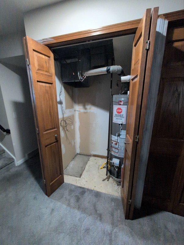Completed removal of residential furnace and air conditioning system from utility closet as part of under one-year test drive program. Disconnected and extracted HVAC equipment, including ductwork connections, electrical wiring, and associated mechanical components. Documented pre-removal conditions showing water heater proximity, existing ductwork configuration, and utility closet layout for future reference.
