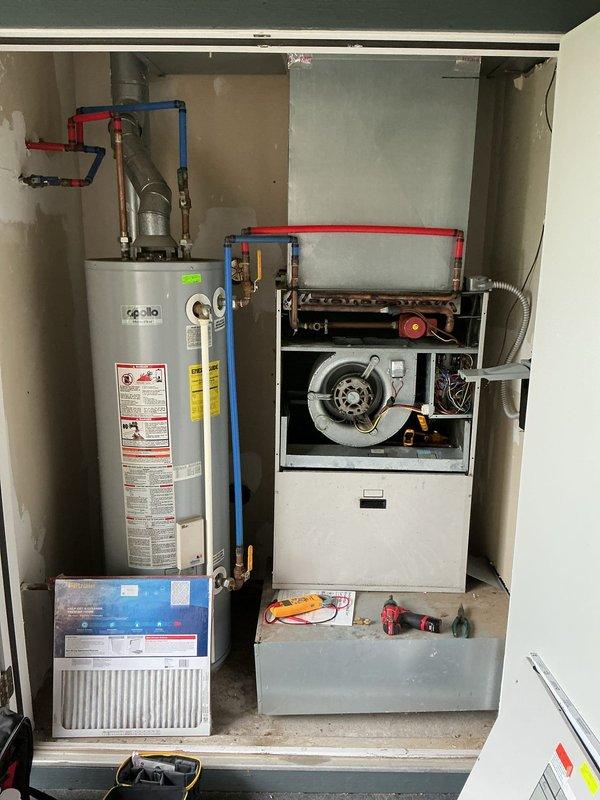 Responded to no-cooling complaint on 15-year-old air conditioning system with operational blower motor but no refrigerant cooling. Accessed furnace/air handler unit to inspect internal components and blower assembly. Evaluated compressor operation, refrigerant system components, and electrical connections to diagnose cooling failure. Documented equipment condition and internal components including blower fan assembly and heat exchanger configuration for diagnostic purposes.