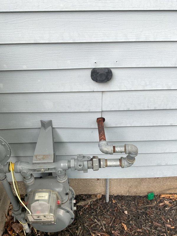 Replaced corroded 12-inch gas pipe section connecting the meter to the home's interior supply line. The existing galvanized steel pipe exhibited significant rust deterioration and was removed and replaced with new piping to ensure safe gas delivery and prevent potential leaks.