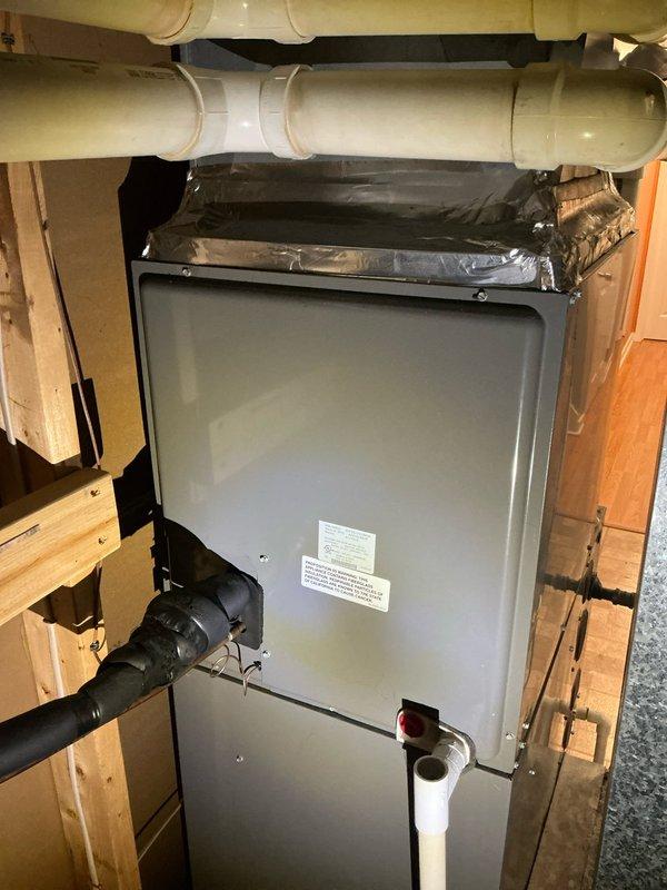Conducted comprehensive evaluation of existing HVAC system for furnace and air conditioning replacement estimate due to non-operational AC unit. Inspected air handler unit installed in basement utility area, documented equipment specifications, condensate drainage system with PVC piping, and overall system configuration within confined mechanical space. Assessed installation requirements, electrical connections, ductwork connections, and structural considerations for potential equipment replacement to provide customer with accurate estimate for new furnace and AC system.