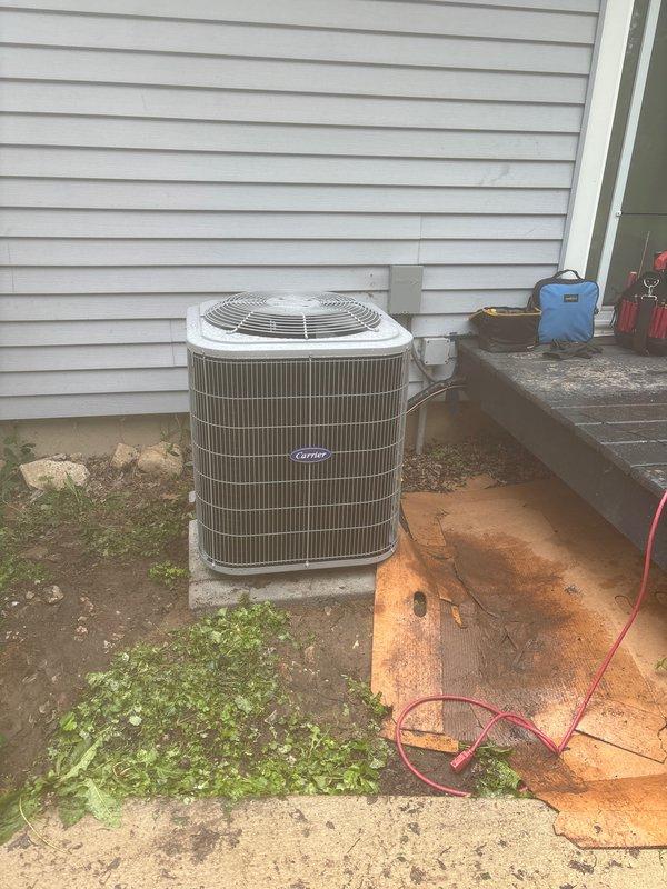 Completed full HVAC system installation including a new Carrier gas furnace and matching Carrier condenser unit. Furnace was installed in basement utility area with proper ductwork connections and drain pan placement. Outdoor condenser unit was positioned on concrete pad against building exterior with electrical connections completed. All equipment tested and operational upon completion of installation.