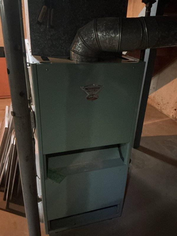 Responded to no-cooling complaint on 15-year-old residential air conditioning system. Upon arrival, customer reported no air flow from vents despite system running with audible operation. Performed diagnostic evaluation of both indoor air handler and outdoor condensing unit. Inspected vintage furnace/air handler assembly in basement and outdoor condenser unit, noting age-related wear on equipment and ductwork. Documented equipment condition with photos showing encroaching vegetation around outdoor unit and deteriorated flexible ductwork connections. System assessed for repair feasibility versus replacement recommendation given age and condition of components.