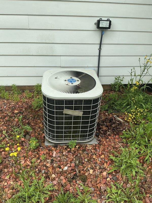 Responded to no-cooling complaint on 15-year-old residential air conditioning system. Upon arrival, customer reported no air flow from vents despite system running with audible operation. Performed diagnostic evaluation of both indoor air handler and outdoor condensing unit. Inspected vintage furnace/air handler assembly in basement and outdoor condenser unit, noting age-related wear on equipment and ductwork. Documented equipment condition with photos showing encroaching vegetation around outdoor unit and deteriorated flexible ductwork connections. System assessed for repair feasibility versus replacement recommendation given age and condition of components.