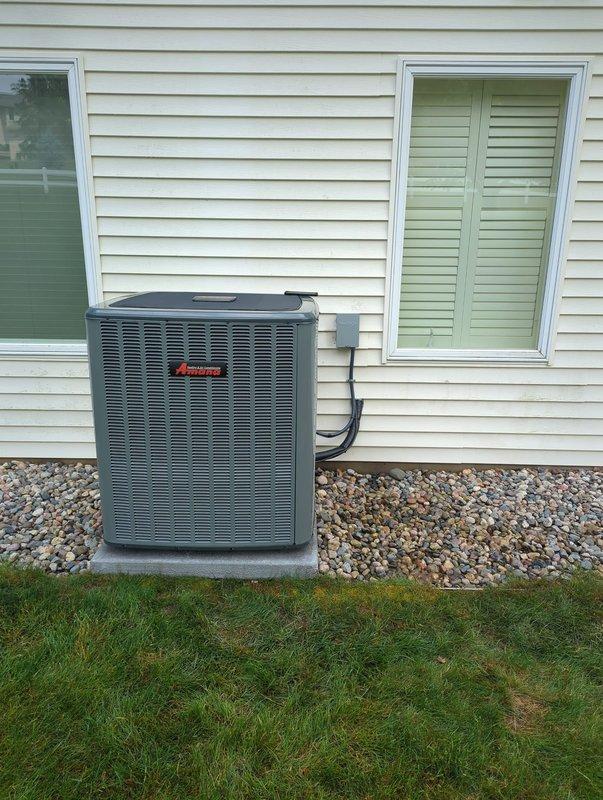 Completed full HVAC system installation including new Amana air conditioning unit and furnace with Aprilaire humidifier integration. The outdoor AC condenser was positioned on a concrete pad with proper gravel base and electrical conduit run, while the indoor furnace was installed in the basement mechanical room with all necessary ductwork connections and humidification system properly integrated into the supply plenum.