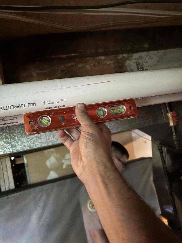 Responded to inspector correction regarding inadequate slope on furnace vent pipe. Verified and documented proper 1/4" per foot upward slope from furnace to termination point on PVC vent piping. Provided detailed photographic documentation of corrected pitch measurements and level verification as requested by building inspector to satisfy code compliance requirements.
