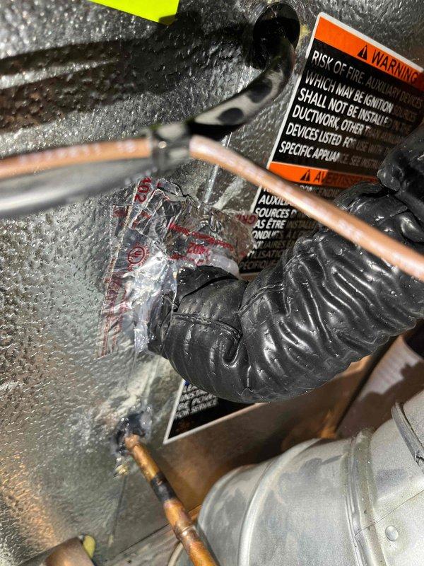 Completed CORR inspection corrections by installing proper insulation at the evaporator coil and installing line set grommets where refrigerant lines penetrate through surfaces. Documented corrected installation with photos showing properly insulated copper refrigerant lines and grommets in place per inspector requirements.