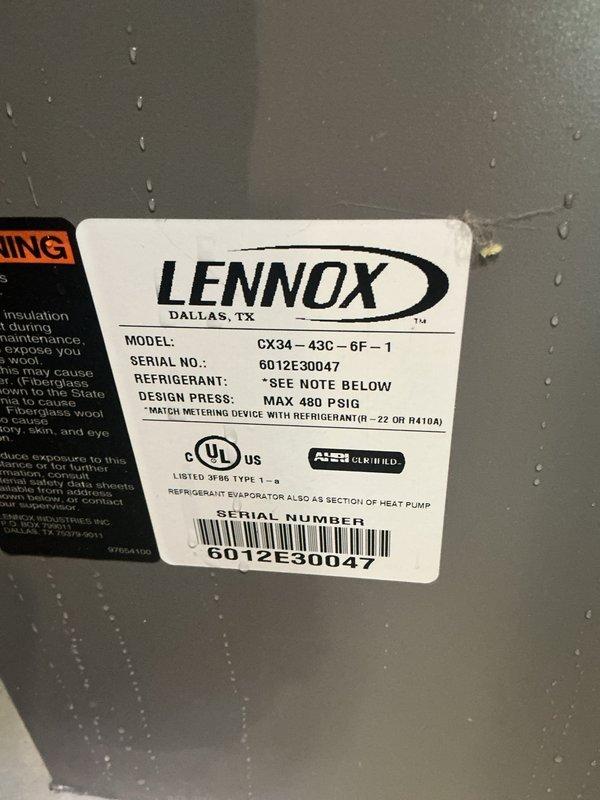 Responded to water leak complaint with pooling under HVAC unit during AC operation. Inspected 15-year-old Lennox condensing unit (Model CX34-43C-6F-1) and found active condensation on equipment surfaces. Documented water accumulation on basement floor beneath furnace/AC system with photographic evidence showing moisture present on unit casing and surrounding area. Identified condensate drainage issue as source of water pooling during cooling cycle operation.