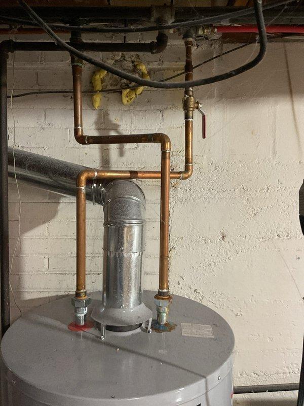 Provided estimate for replacement of aging residential water heater unit (9-12 years old) that is no longer functioning properly. Scope of work includes complete removal and disposal of existing water heater and installation of new unit with proper connections to existing copper supply lines, shut-off valves, and expansion tank. Minor wall deterioration and moisture damage observed in installation area, indicating possible historical water heater issues.