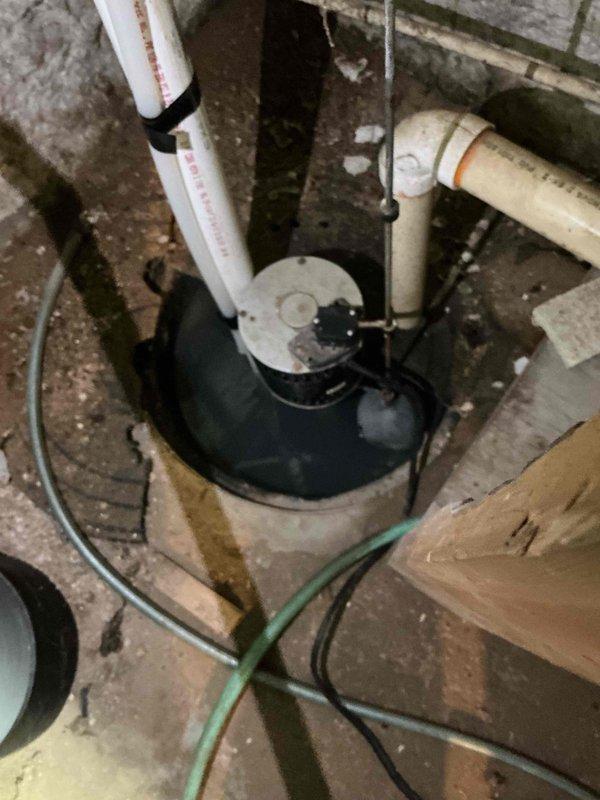 Responded to sump pump failure where unit was running continuously but not pumping water. Upon inspection of the 180-year-old property's basement sump pit, diagnosed malfunctioning pump motor and float switch assembly. Removed failed sump pump unit from concrete pit and installed replacement pump with new discharge piping connections to existing PVC system. Tested pump operation through multiple cycles to verify proper float switch engagement and automatic shutoff functionality. Confirmed adequate water discharge through vertical piping and verified no leaks at connection points. System now operating correctly with proper on/off cycling.