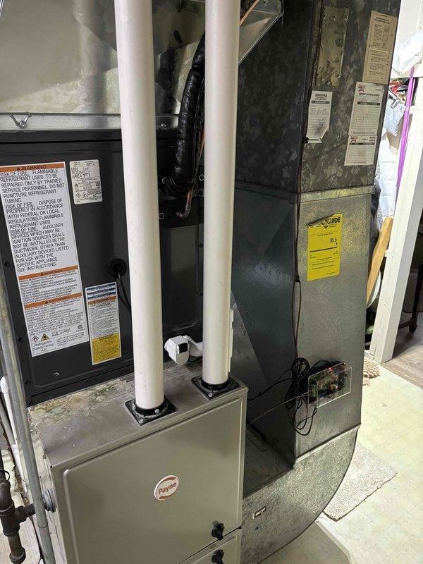 Completed full HVAC system replacement including outdoor condensing unit and indoor air handler. Installed new condenser on existing concrete pad with proper refrigerant line connections and condensate drain piping routed through exterior wall-mounted PVC system. Connected electrical service to outdoor disconnect box and verified proper power supply. Indoor equipment positioned in basement utility area with appropriate venting configuration and all safety labels intact. System tested for proper operation, refrigerant charge verified, and all connections leak-checked and secured.