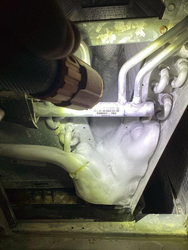 Responded to cooling complaint where system was running but unable to maintain setpoint, with thermostat reading 74°F despite being set to 70°F. Upon inspection, discovered water accumulation in the blower unit and extensive frost/ice buildup on evaporator coil and condensate drain lines. Identified restricted airflow and potential refrigerant issue causing freezing conditions within the air handler. Inspected electrical connections and wiring at the unit. Documented conditions with photos showing frozen condensate lines and ice-covered components. System exhibited symptoms consistent with restricted airflow or low refrigerant charge, similar to previous year's service history. Further diagnostics recommended to determine root cause of recurring cooling capacity issues and water intrusion in blower compartment.