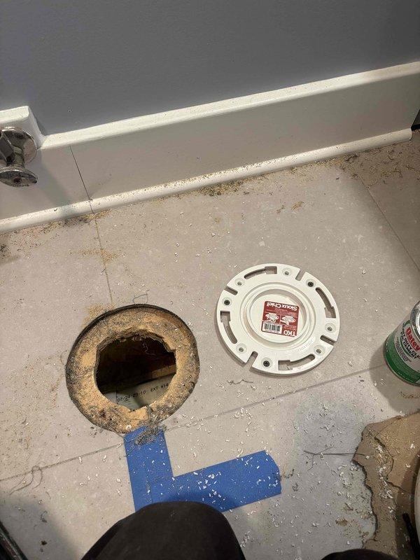 Replaced corroded toilet flange assembly showing significant rust deterioration around the drain opening. Removed old flange, cleaned mounting surface, and installed new PVC flange with proper seal to prevent future leaks and ensure secure toilet mounting.