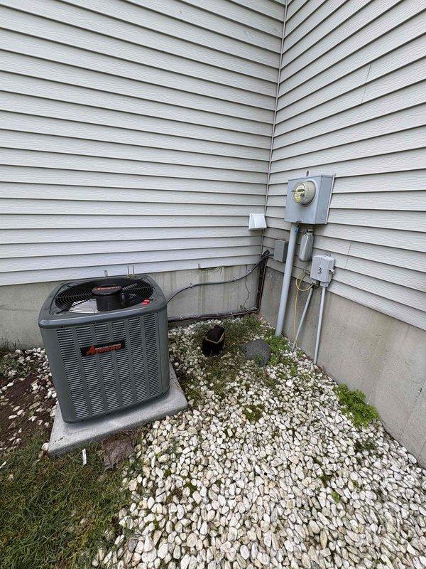 Completed full air conditioning system replacement at residential property. Removed existing AC unit and installed new Trane air conditioning system on exterior concrete pad with proper positioning adjacent to electrical meter and service panel. Installed new air handler unit in basement utility area alongside existing furnace, ensuring proper clearances and access for future maintenance. Ran white PVC condensate drainage piping from air handler with appropriate pitch and routing through basement ceiling joists. Connected electrical service via conduit to exterior disconnect and verified proper voltage and amperage at unit. Tested system operation including compressor startup, refrigerant pressures, airflow, and thermostat communication. Confirmed all connections are secure, system is cooling effectively, and installation meets manufacturer specifications and local code requirements.