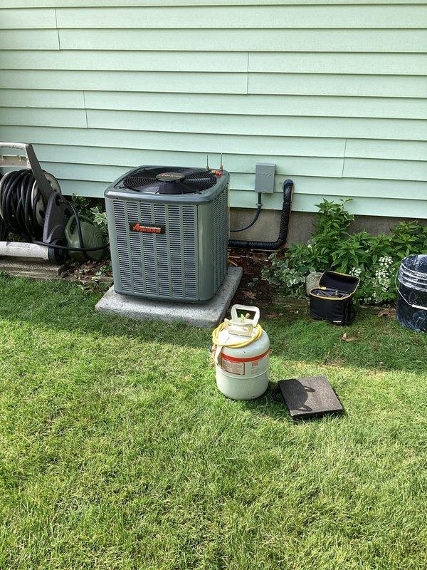 Complete HVAC system replacement performed at residential property. Removed existing air conditioning condenser unit and indoor air handler from basement utility room. Installed new teal-colored outdoor condenser unit on concrete pad with proper electrical disconnect and conduit routing. Replaced indoor air handler in basement mechanical room with new unit, ensuring proper clearances around existing PVC drainage lines and utilities. Evacuated and recharged refrigerant lines using recovery equipment. Verified all electrical connections, tested system operation, and confirmed proper airflow and cooling performance. System commissioned and left in full working order.