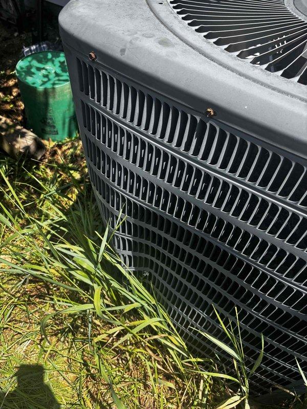 Responded to no heat call for HVAC system not turning on. Upon arrival, located outdoor condensing unit with significant vegetation growth around base and sides, potentially restricting airflow to coil. Unit showed signs of weathering and debris accumulation on exterior surfaces. Performed system diagnostic to determine cause of no operation. Customer reported filters changed regularly. Documented equipment condition with photos showing grass and weeds in close proximity to condenser requiring clearance maintenance. Unit accessibility partially compromised by overgrown landscaping. Assessed electrical components, thermostat communication, and safety controls to identify failure point preventing system startup.
