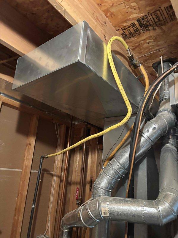 Completed annual cooling maintenance on 19-20 year old Goodman AC system. Performed comprehensive inspection of outdoor condensing unit and indoor air handler, checked refrigerant lines and electrical connections, verified proper operation of all components, and documented system condition with photos showing both exterior unit installation and interior ductwork configuration.