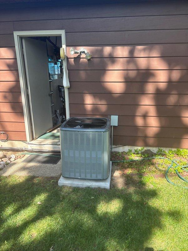Completed full air conditioning system replacement at residential property. Installed new outdoor condenser unit on existing concrete pad with proper clearances and leveling, positioned adjacent to utility room access door. Interior installation included new furnace unit in basement utility area with complete ductwork connections, proper venting, and integration with existing plumbing and electrical systems. All work performed per manufacturer specifications and local code requirements, system tested and operational upon completion.