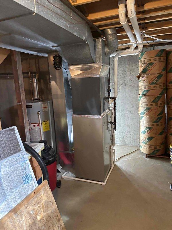 Completed full air conditioning system replacement at residential property. Installed new outdoor condenser unit on existing concrete pad with proper clearances and leveling, positioned adjacent to utility room access door. Interior installation included new furnace unit in basement utility area with complete ductwork connections, proper venting, and integration with existing plumbing and electrical systems. All work performed per manufacturer specifications and local code requirements, system tested and operational upon completion.