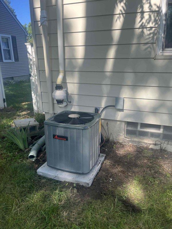 Completed full air conditioning system replacement including outdoor Amana condensing unit and indoor air handler. Installed new condenser on existing concrete pad with proper refrigerant line set routing along exterior wall using appropriate insulation and secure mounting. Connected white PVC condensate drainage and verified proper pitch for drainage flow. Installed matching indoor air handler in basement mechanical room with integration to existing ductwork system. Ran and secured refrigerant lines from outdoor unit through wall penetration to indoor coil. Completed all electrical connections, pressure tested refrigerant lines for leaks, evacuated system to proper vacuum levels, and charged unit to manufacturer specifications. Verified proper airflow, temperature split across coil, and system operation through complete cooling cycle. All components functioning within normal parameters upon departure.