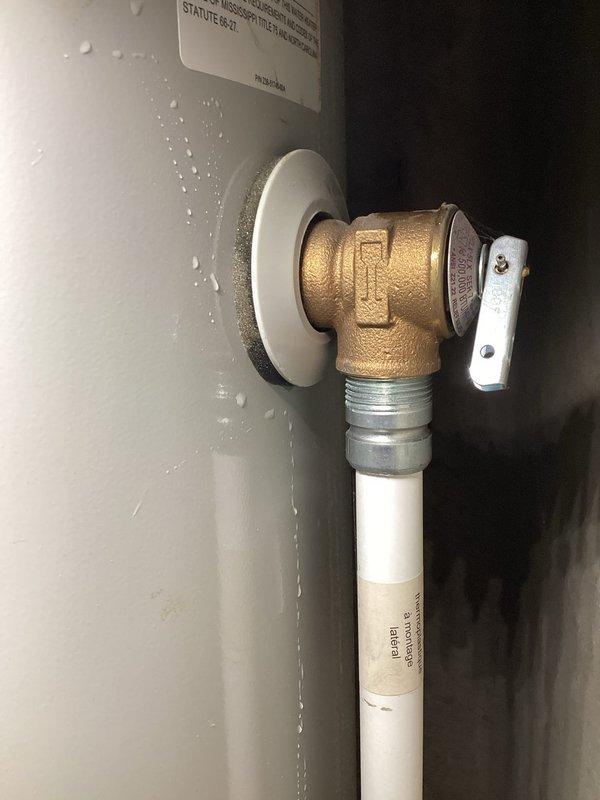 Responded to service call for 8-year-old Bradford White water heater with pilot light failure and water accumulation in catch pan. Upon inspection, diagnosed failed thermocouple preventing pilot from staying lit. Observed minor water leakage at base of unit collecting in drain pan, indicating potential tank integrity issues given age of equipment. Documented equipment condition with photos showing space heating connection port and water supply valve assembly with visible moisture on wall surfaces. Recommended water heater replacement due to combination of failed pilot assembly and water seepage from tank base.