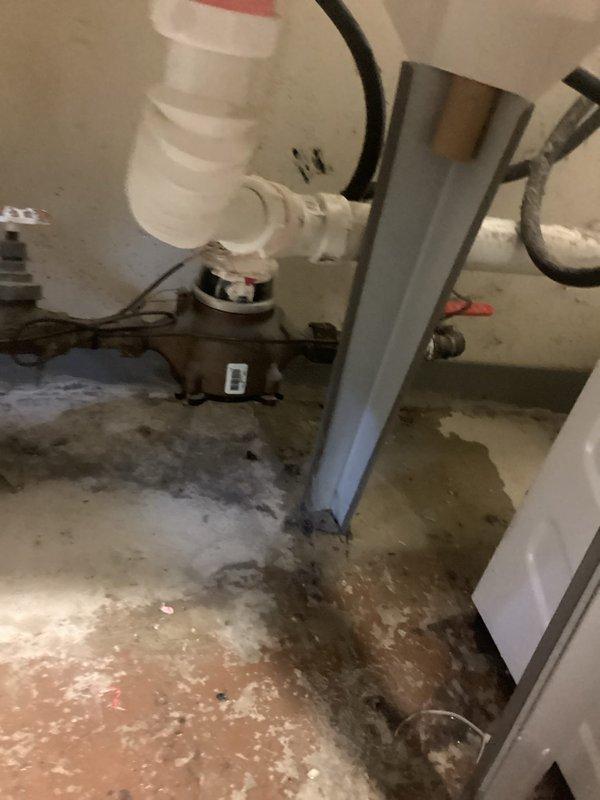 Replaced the main water shut-off valve on the house side of the plumbing system. The existing valve showed signs of failure, and the surrounding concrete floor exhibited extensive water damage and staining from previous leaks. Successfully installed new shut-off valve with red handle for easy identification and operation, ensuring proper water control to the residence.