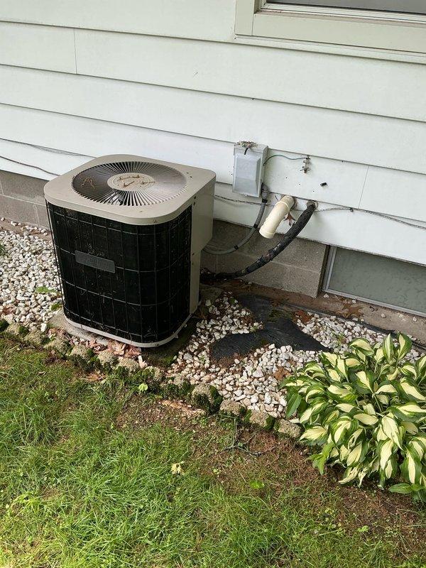 Performed estimate for non-operational air conditioning system at residential property. Inspected outdoor condenser unit with black grille body and beige top cover, along with associated refrigerant lines and wall penetrations. Evaluated basement HVAC equipment including Tempstar furnace, metal plenum cabinet, and ductwork connections. Documented existing system conditions with photos to provide replacement options for homeowner decision-making process.