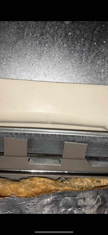 Responded to air conditioning leak complaint on 5-year-old York system. Upon inspection, accessed air handler unit and identified water leakage issue. Inspected internal components including air filter housing, evaporator coil area, and condensate drainage system. Documented equipment condition showing normal operational wear with dust accumulation on metal panels and interior components. Verified proper sealing around insulation and ductwork connections. Photographed findings for service records.