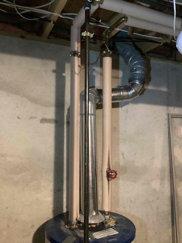 Completed water heater replacement estimate for owner-occupied residence with existing unit over 20 years old. Assessed current installation including copper supply piping, flue venting system, pressure relief valve, and mixing valve configuration in basement utility area. Documented existing equipment condition and provided replacement recommendations per current building codes and manufacturer specifications.